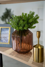 Styled photo of pink Abbott vase in between blue and gold photoframe and gold candleholder on a light brown shelf