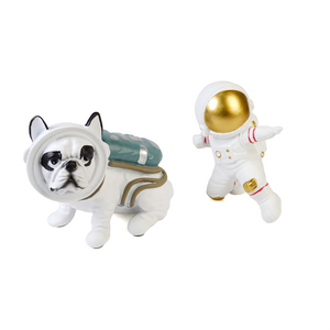 Dog figurine beside astronaut figurine