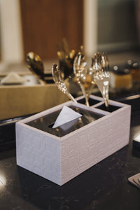 Granada beige tissue box containing tissue and gold cutlery on a black marble pantry table