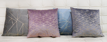 Bardot pink cushion with other geometric patterned cushions in grey and blue on a white leather quilted sofa