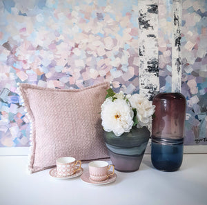 Winter Days acrylic painting serves as a backdrop for pink-themed home decor accessories such as cushion, vases and teacup sets.