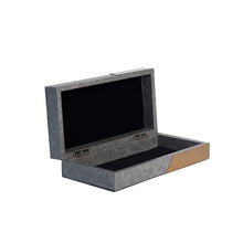 Side view of open Corsica box with smooth pebble grey faux leather, gold metal panels and black suede inner lining
