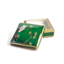 Front view of open green Emery box with tree and bird motifs and gold borders on a green ceramic base with white ceramic inner