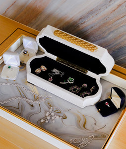Brixton white box filled with colourful jewelry on white and gold marble tray with ring boxes and other jewelry