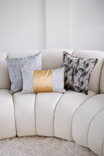 Aspen grey cushion next to Brompton blue and gold cushion and Aspen mint blue cushion on a cream boucle sofa