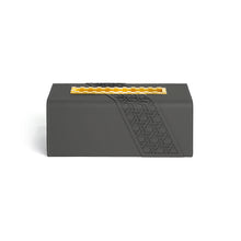 Front view of Tatum tissue box with geometric pattern on dark grey faux leather and yellow indented metal opening